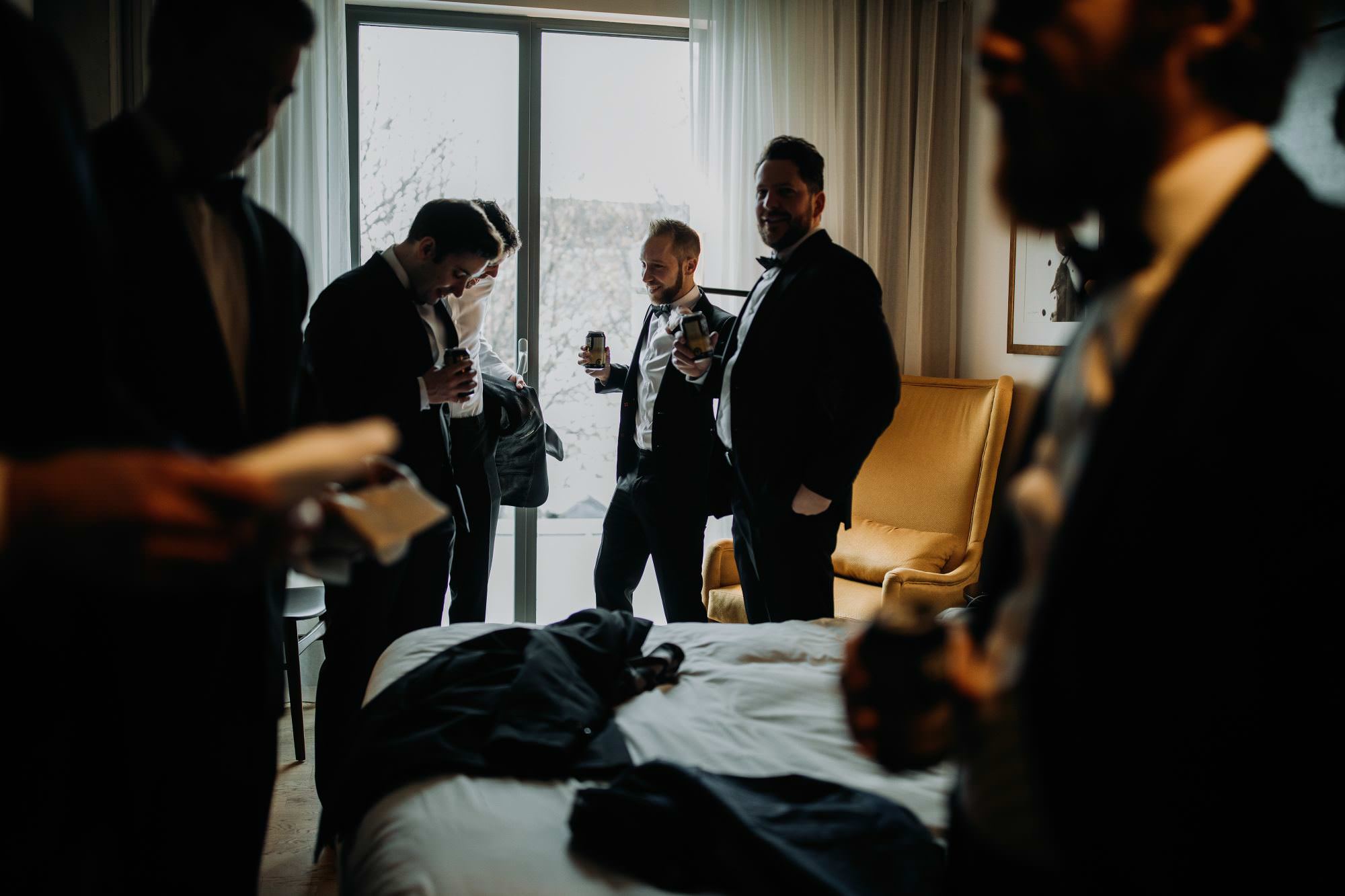 groomsmen drinking beer in hotel room