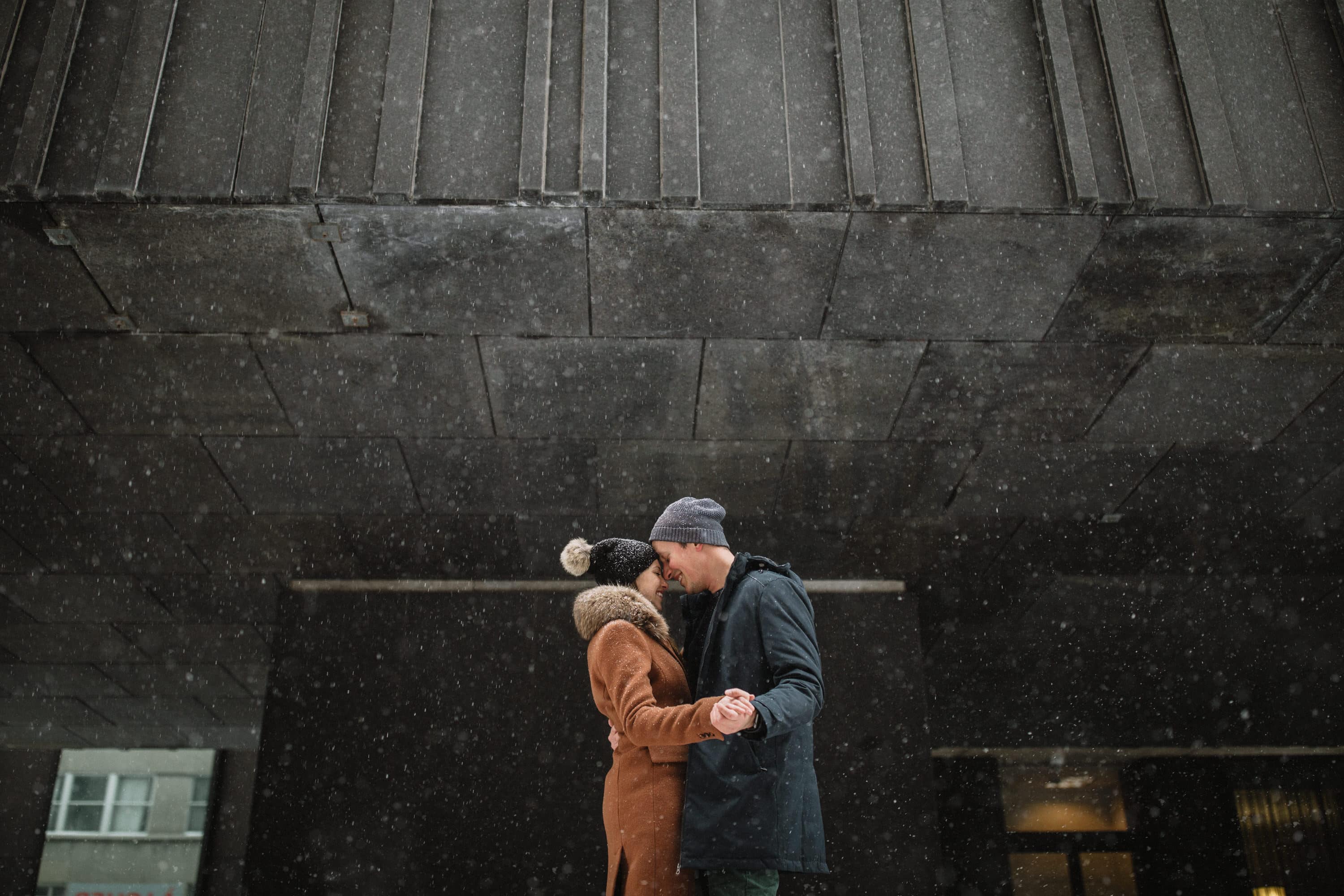 A playful embrace near notre dame street during their old port Montreal engagement session with photographer Brent Calis.