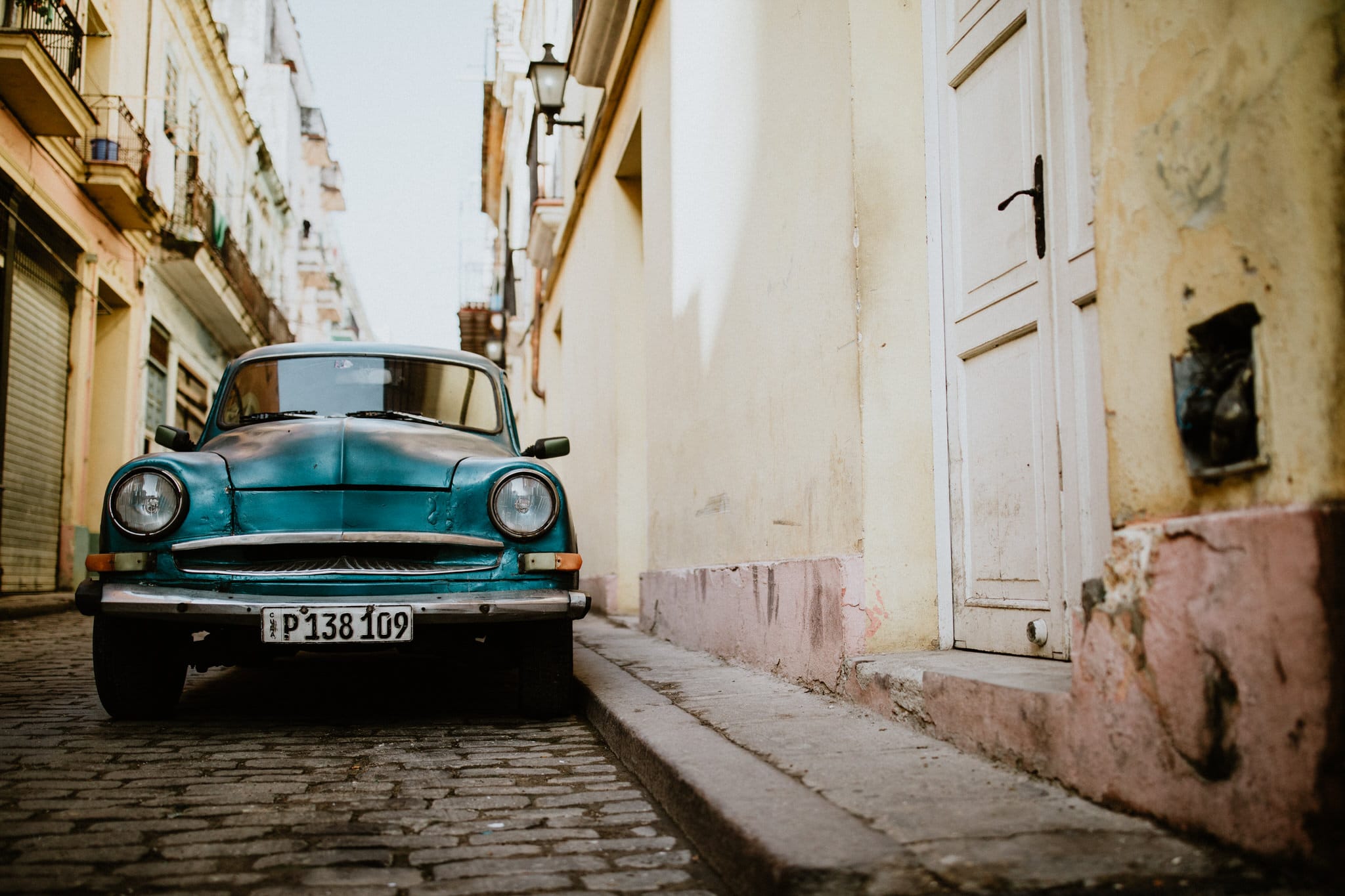 Classic cars and cobblestone streets in Havana, Cuba. Travel photographer Brent Calis.