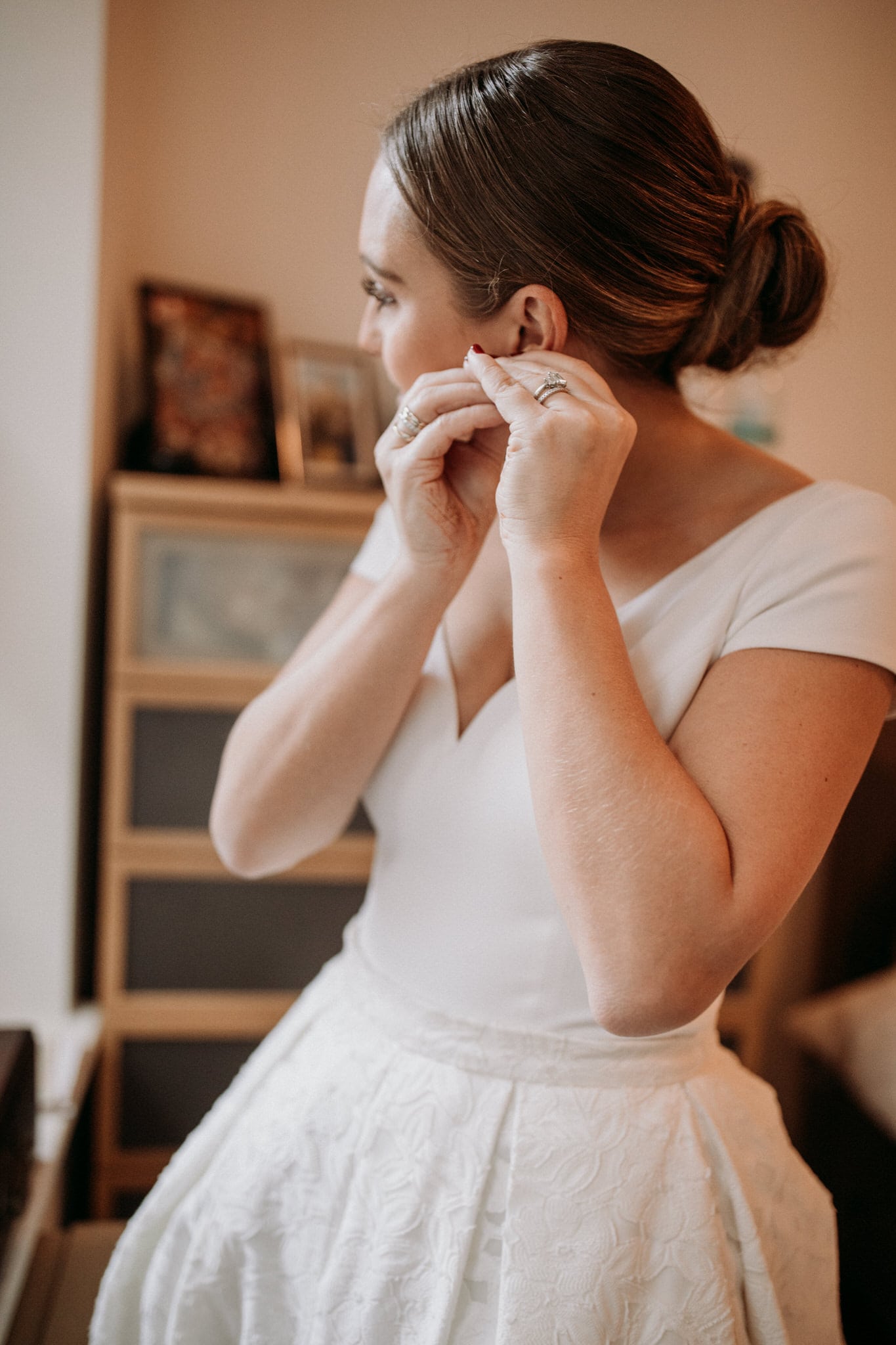 The bride puts on her earrings. Wedding Photographer Brent Calis.