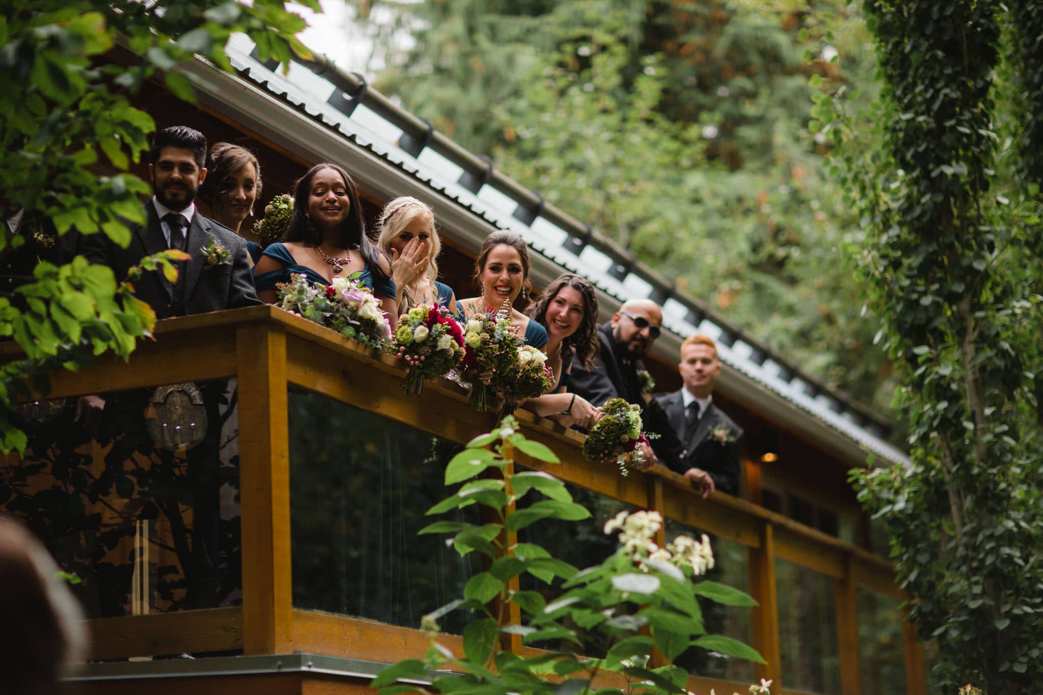 Bridal party watch first look from balcony at The Brew Creek Centre in Whistler. Destination wedding photographer Brent Calis.