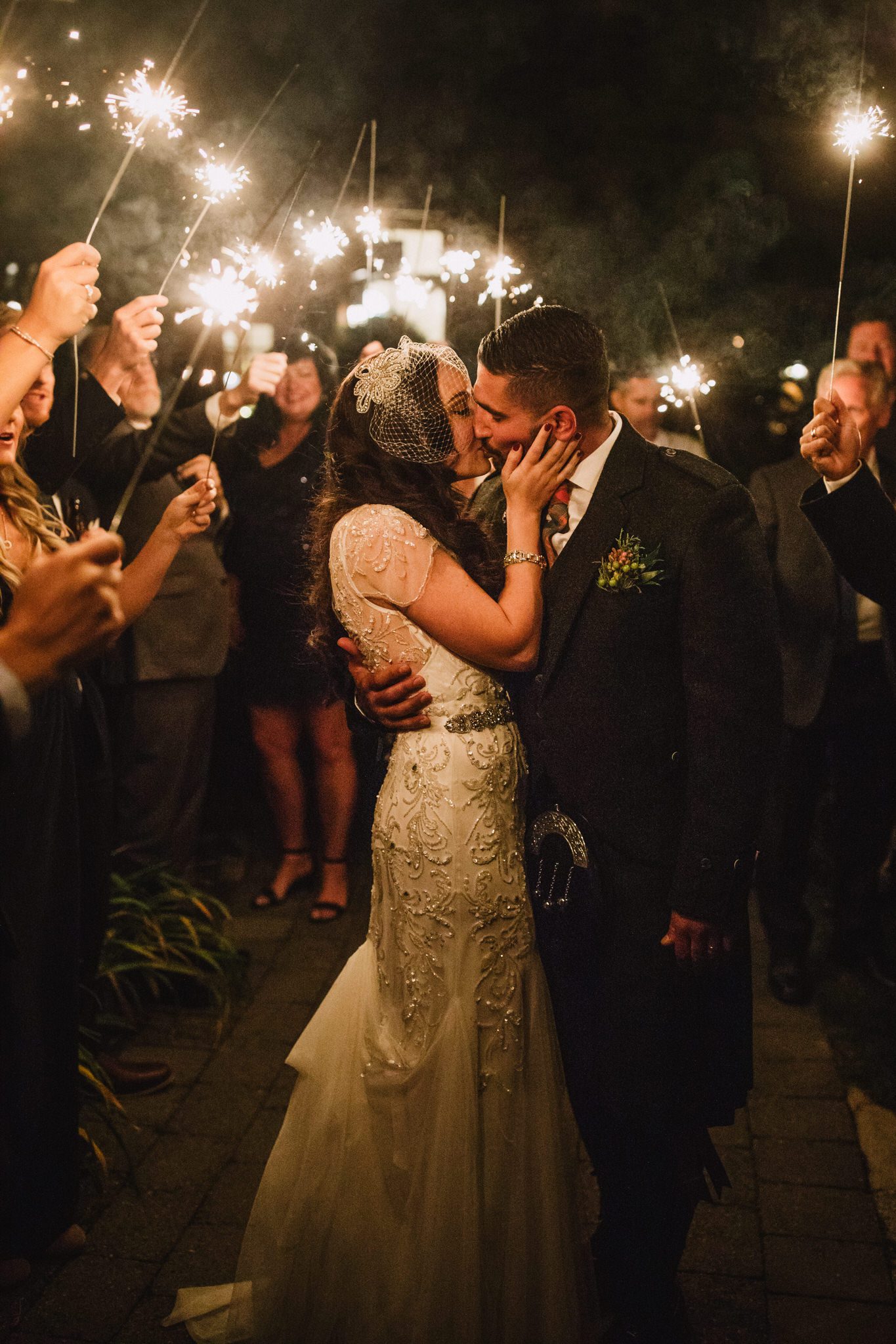 Couple kisses during a sparkler exit at a wedding at Brew Creek Lodge, Whistler