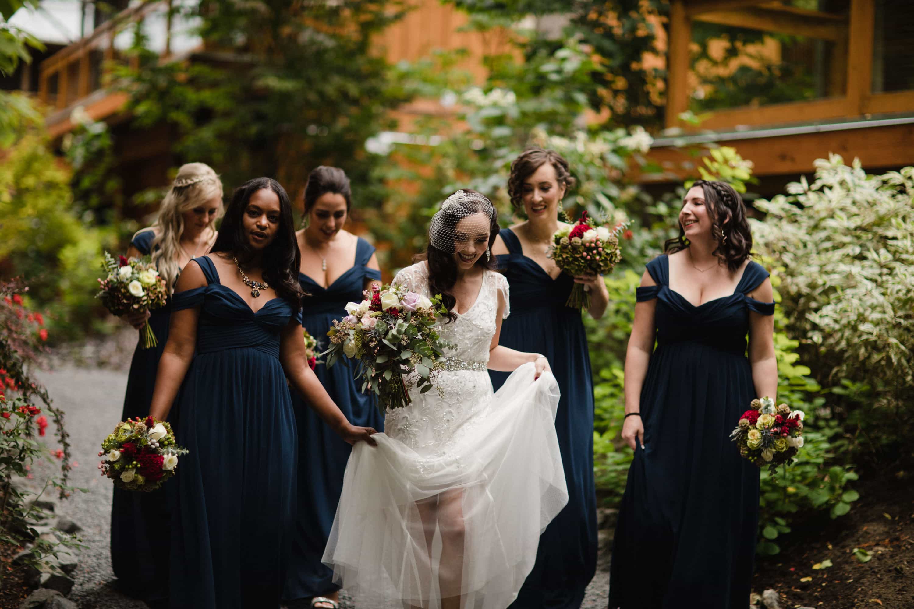 Bridesmaids walk through nature to wedding ceremony