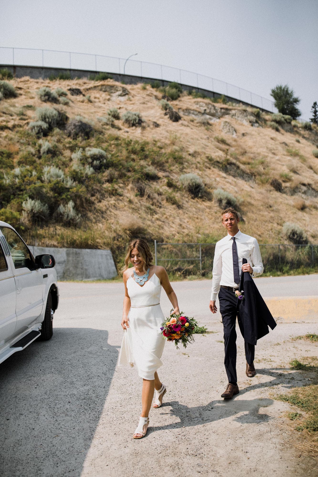Bride and groom walk to the limo. Destination wedding photographer Brent Calis.